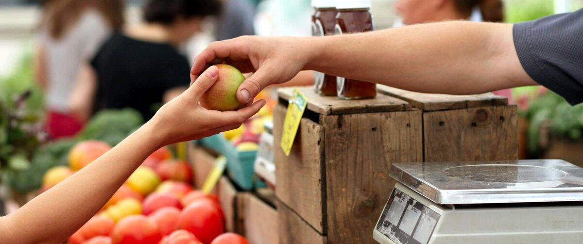 a person buying an apple in a local market