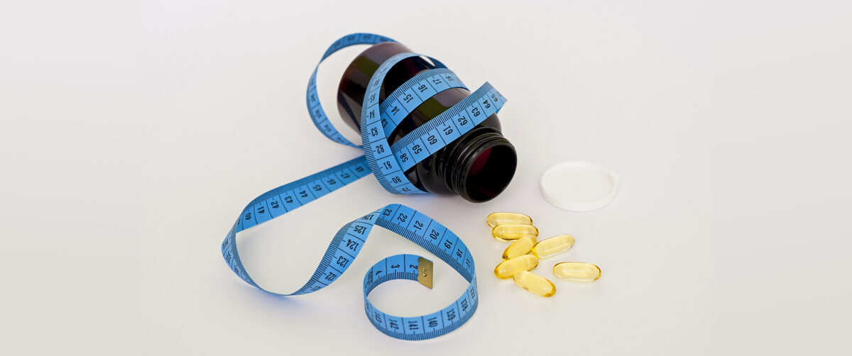 omega 3 supplements and a tape measure