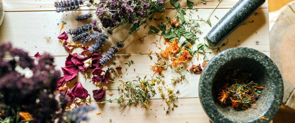 medicinal herbs being mashed and mixed in a mortar
