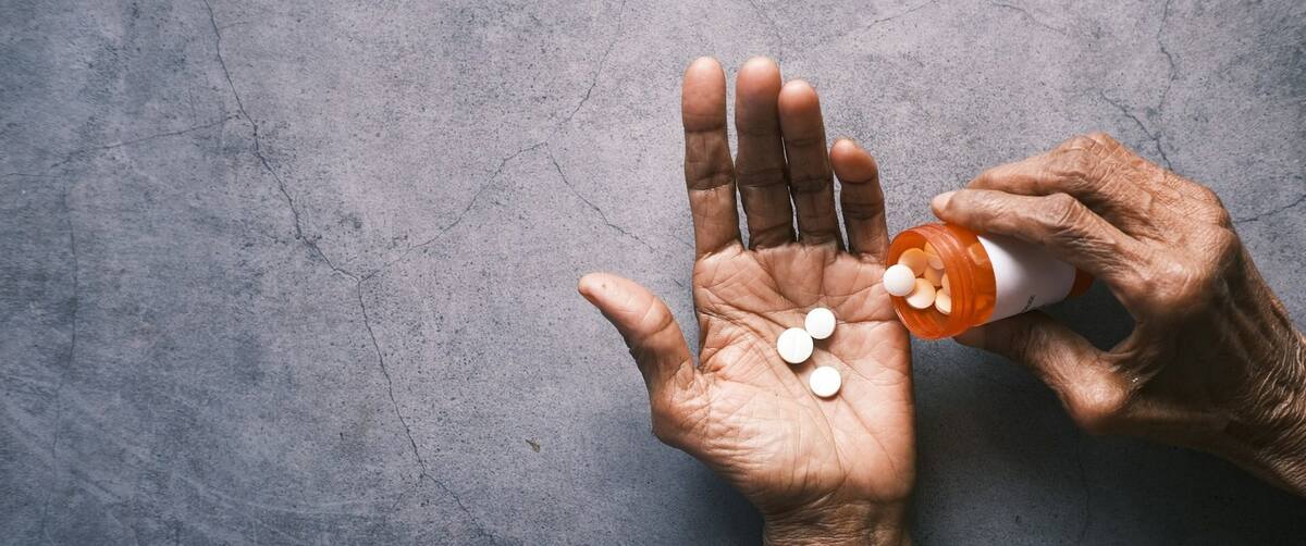 a person dropping pharmacological pills in the hand
