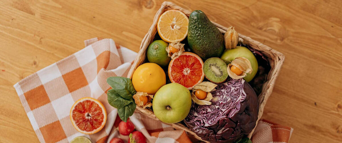 a basket of fresh fruits and vegetables ready to be eaten in a picnic