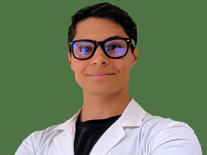 Tom with googles and a lab coat in a green background